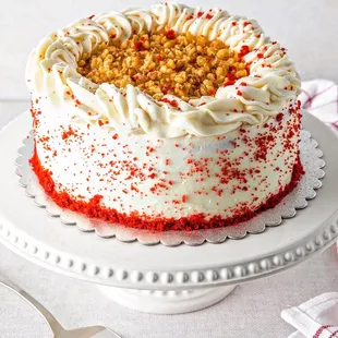 a red velvet cake with white frosting and sprinkles