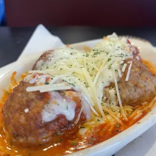 two meatballs covered in sauce and cheese