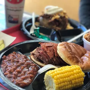 BBQ sandwich, corn cobette,and baked beans.