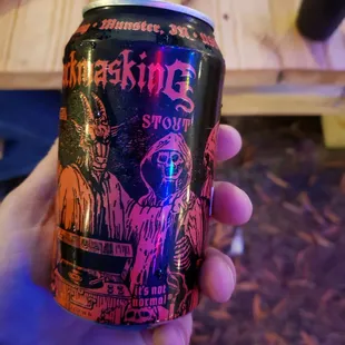 a person holding a can of beer