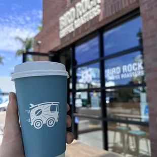 a hand holding a cup of coffee