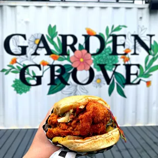 a hand holding a sandwich