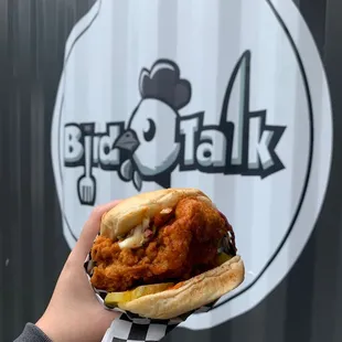 a hand holding a sandwich