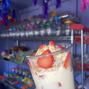a hand holding a glass of yogurt