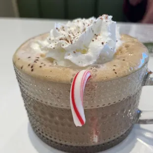 a hot chocolate with whipped cream and candy cane