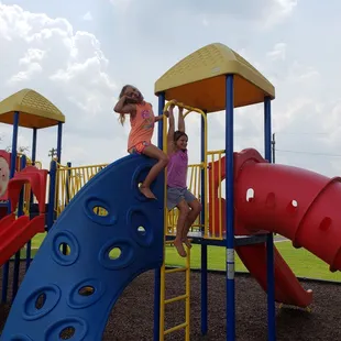 two children climbing on a playground structure