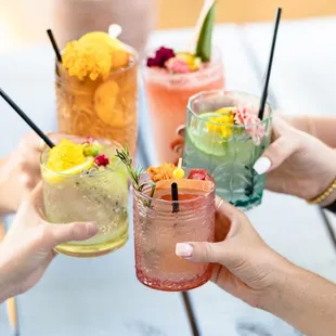 a group of people toasting with cocktails