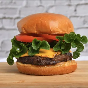 a cheeseburger with lettuce and tomato
