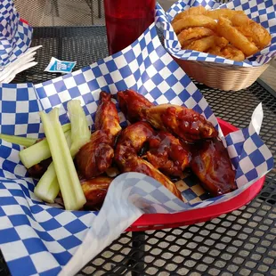 a basket of chicken wings and celery sticks