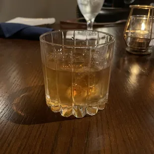 a glass of whiskey on a wooden table