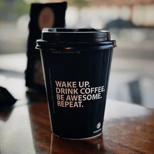 a cup of coffee with the words wake up, drink coffee, be awesome, repeat