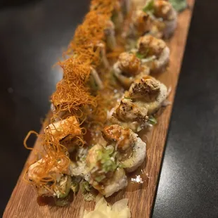 a long wooden platter of sushi