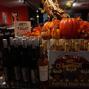 a display of wine bottles and pumpkins