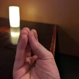 a hand holding a lit candle
