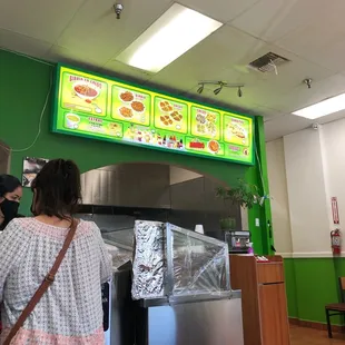 a woman standing in front of a menu