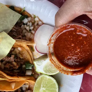 a person holding a glass of salsa