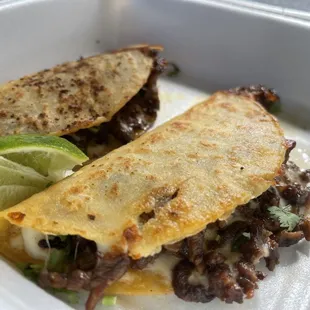 Quesaasada tacos. Asada and cheese in corn tortilla made to a crispy with onion and cilantro