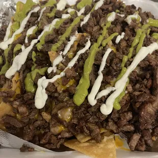 Asada Nachos. Homemade tortilla chips prepared with refried beans, cheese, sour cream, Guac and pico