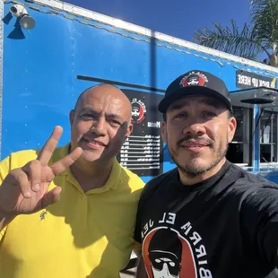 two men in front of a food truck