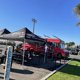 a red food truck parked in a parking lot