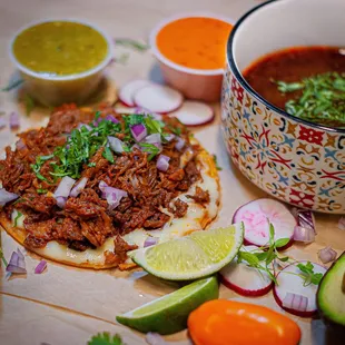 a bowl of salsa, a bowl of chili, a bowl of salsa, and a tortill