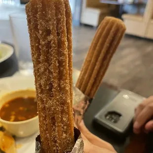a person holding a churros