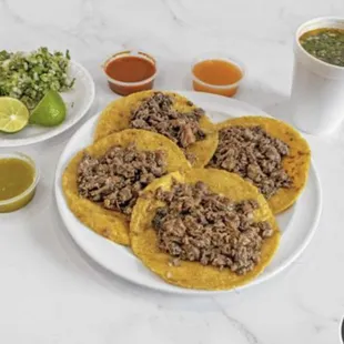 a plate of beef tacos and a cup of salsa