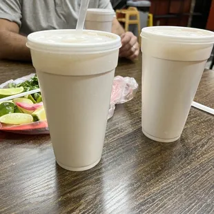 a man sitting at a table with two cups of coffee