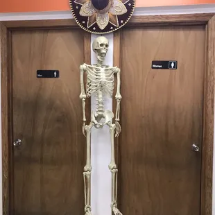 a skeleton standing in front of a door