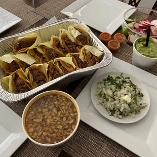 Tacos suaves plain con verdura a lado , cebolla cilantro, limones rábanos . Y un consomé grande .