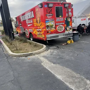a red food truck parked in a parking lot
