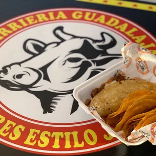 a sandwich and chips in a paper container