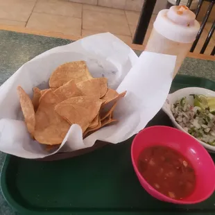 Chips,salsa and condiments for tacos.