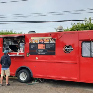 a man ordering food from a red food truck