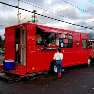 a woman standing in front of a food truck