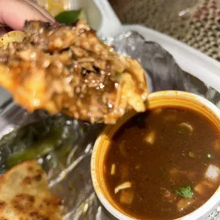 a person dipping a piece of pizza