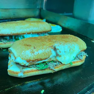 two sub sandwiches on a grill