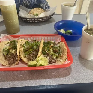 3 Birria Tacos with chorizo, onions, lettuce, topped with lime juice and consume to dip the tacos in. With a Horchata to drink!