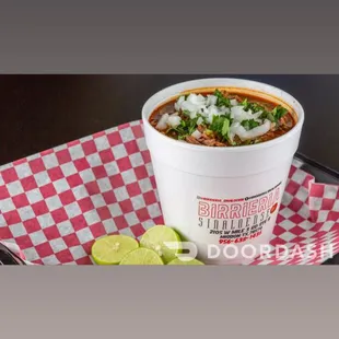 a bowl of chili and a slice of lime