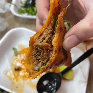 a hand holding a half eaten sandwich