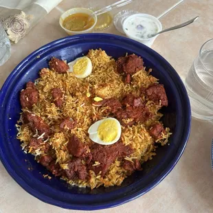 Boneless chicken biryani with gravy and Raita .