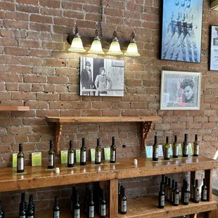 a brick wall and shelves with bottles of olive oil