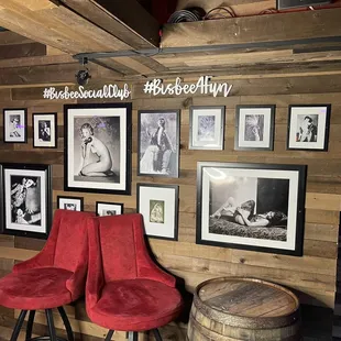 two red chairs in front of a wooden wall
