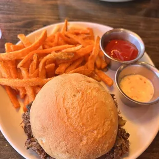 Braised short rib sandwich on gluten free bun with sweet potato fries
