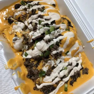 a tray of cheese and meat nachos