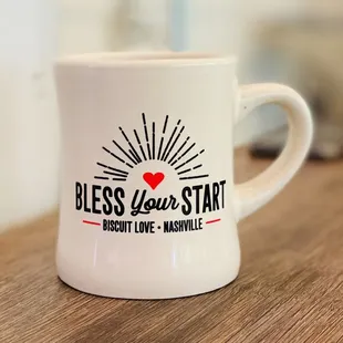 a coffee mug with the words bless you start biscuit love marshall