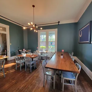 a dining room with blue walls and wood floors