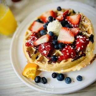 a waffle topped with strawberries and blueberries