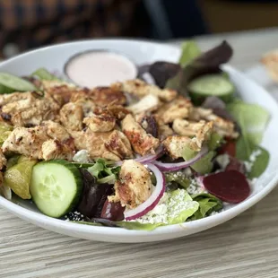 Greek Salad + Grilled Chicken. Tossed garden greens, tomatoes, onions, cucumbers, olives, beets, green peppers, pepperoncini, and feta chees