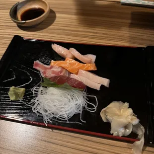 a plate of sushi and a bowl of sauce